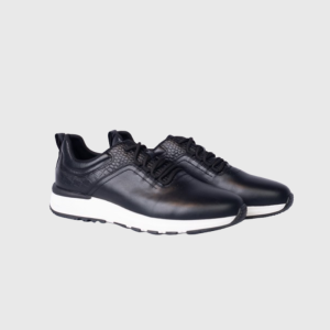 Black leather casual sneakers with white soles on a gray background.